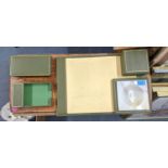 A stationery set comprising three leather bound green and gold coloured gilding storage boxes, a
