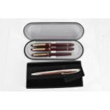 A cased set of pens, comprising two fountain and one ballpoint pen, each with maroon barrel and gilt