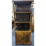 A Chinese stained elm cabinet having a moulded cornice, three open shelves and two cupboard doors