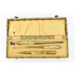 An early 20th century Art Deco cased desk set, in marbled bakelite and gold coloured metal,