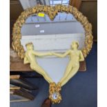 A modern heart shaped mirror decorated with gold coloured ivy leaves and two figures resembling Adam