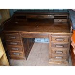 A 1930's/40's oak roll top twin pedestal desk having a fitted interior and nine drawers, 109cm h x