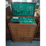 A vintage Chinese cutlery cabinet having a hinged top with drawers and cupboards below, containing