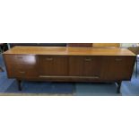 A mid 20th century G-Plan E Gomme sideboard having three drawers, two bi-fold doors and fall-down