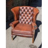 A mid 20th century brown leather 'Chesterfield' wingback armchair on front fluted legs Location: A2M