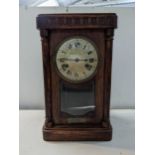A 1920s oak cased mantel clock with a visible pendulum Location:
