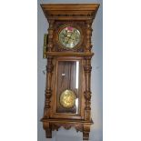A 19th century walnut carved Vienna 8-day wall clock, having a stepped cornice and reeded columns
