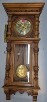 A 19th century walnut carved Vienna 8-day wall clock, having a stepped cornice and reeded columns