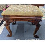 A 19th century tapestry topped footstool having a carved C-scroll frame and on cabriole legs,