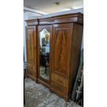 An Edwardian inlaid mahogany breakfront double wardrobe, stepped pediment above a central arched
