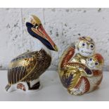 A Royal Crown Derby Pelican paperweight with gold stopper, together with two monkey paperweights