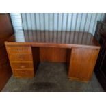 An early/mid 20th century walnut twin pedestal desk having four drawers and single cupboard door,