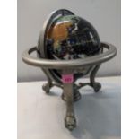 A globe set with semi and non-precious stones set in a metal supporting frame on lion and ball