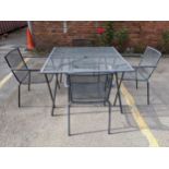 A black finished metal garden table and four matching armchairs, the square mesh topped table with