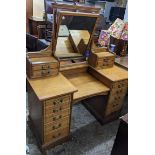 Circa 1900 a tiger oak dressing table having fourteen drawers flanking a mirror, having a stepped