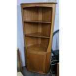 A vintage Ercol blonde elm corner cabinet having open shelves above a cupboard door, 179.5h x 77.5w,