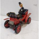 A Japanese tin plate battery operated model of a man driving a vintage car Location: