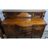 A late Victorian walnut, bow fronted sideboard having a raised mirrored top and drawers flanked by