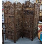 An Indian heavily carved and pieced four folding hardwood screen having floral motifs with repeating