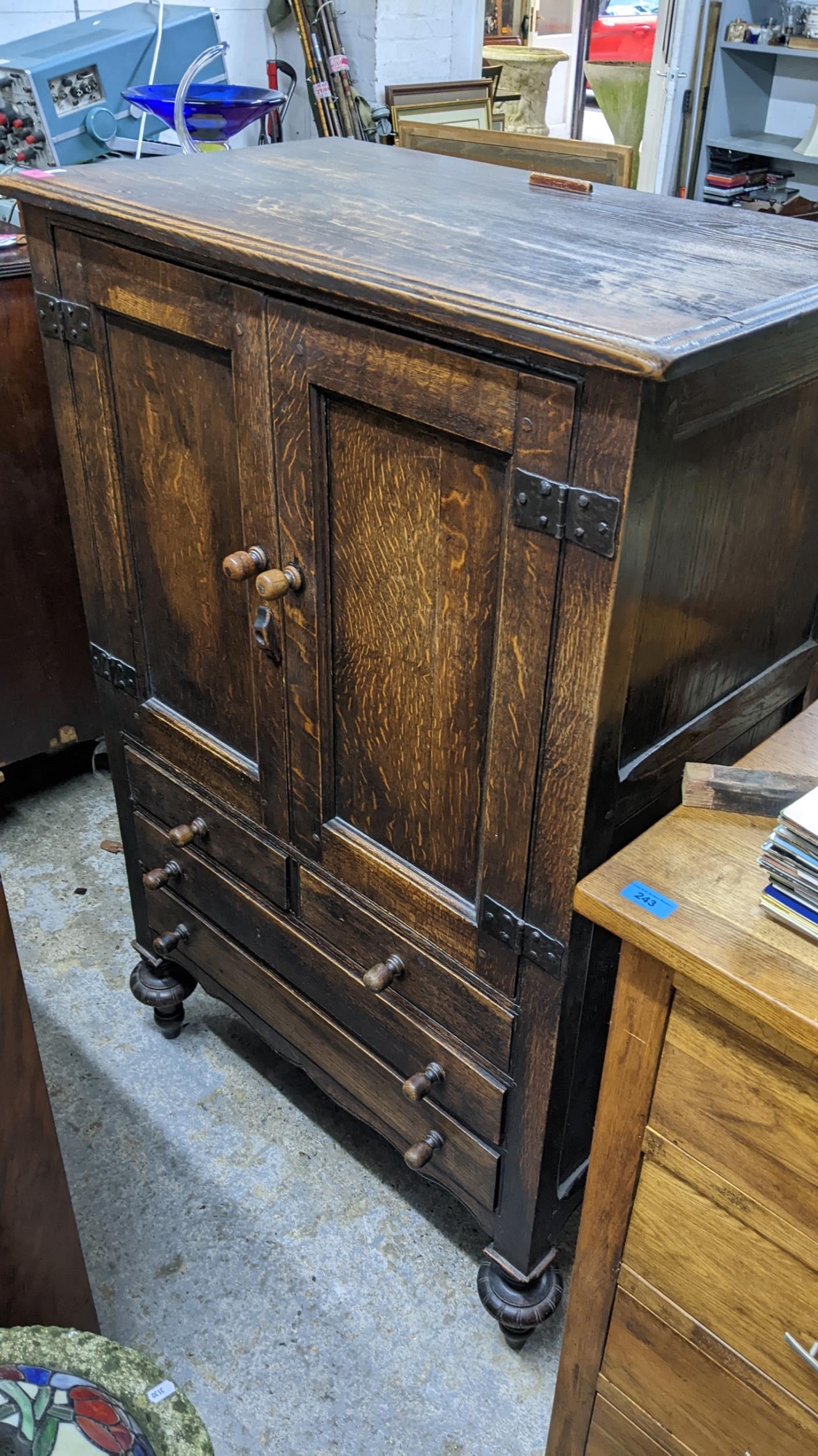 An early 20th century oak cabinet with twin panelled doors, over three drawers, 125H x 81w,