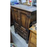 An early 20th century oak cabinet with twin panelled doors, over three drawers, 125H x 81w,