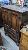 An early 20th century oak cabinet with twin panelled doors, over three drawers, 125H x 81w,