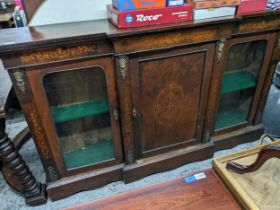 A late Victorian walnut breakfront bookcase having marquetry inlaid decoration and three doors