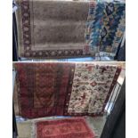 Five mixed rugs to include a hand woven Afghan red ground rug having repeating motifs and