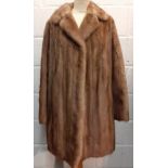 A vintage mid brown musquash coat 44" chest x 36" long together with a silver Jaguar advertising pin