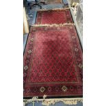 Two Tabriz red ground rugs having repeating motifs and tasselled ends, 195cm x 135cm and 120cm x