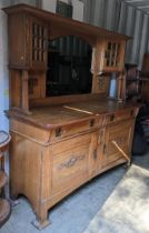 An Arts & Crafts oak sideboard possibly by Liberty with a mirrored back flanked by a pair of