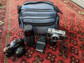 Photographic equipment and accessories to include a Canon A-1, a Konica C35, a 50mm and a 70-210mm