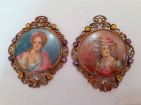 Two early 20th Century painted pendants, one signed Dubois, in gold tone and silver tone filigree