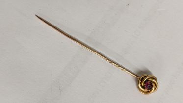 A yellow metal stick pin inset with a single ruby, 1.7g Location: