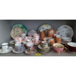 A collection of decorative coffee cans and tea cups with saucers and miscellaneous collectors plates