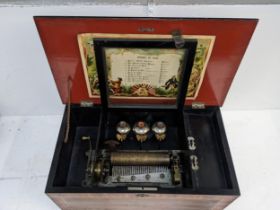 An early 20th century faux grained wood cased musical box with ten airs and three bells, comb