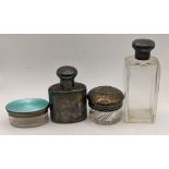 A silver flask with a screw lid, two glass dressing table jars, one with a silver enamelled lid, the