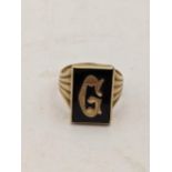 A 9ct gold signet ring set with a non-precious stone inscribed with the letter 'G', 5.0g Location: