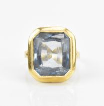An 18ct yellow gold and topaz dress ring, the central radiant cut stone in a rub-over