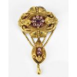 A Victorian Etruscan revival yellow metal and amethyst brooch, with central floral cluster, the