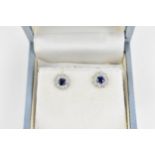 A pair of 18ct white gold, diamond and sapphire cluster earrings, set with central round cut blue