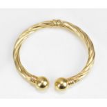 A 9ct Italian yellow gold torque bangle, with twist detail, large bead ends and hinged opening, 12.3