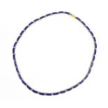 A yellow metal and lapis lazuli necklace, with curved rectangular links each inset with lazuli