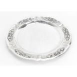 A large Mexican silver circular tray, the border with embossed flowers and leaves on textured