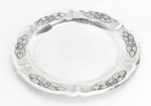A large Mexican silver circular tray, the border with embossed flowers and leaves on textured