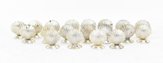 A set of sterling silver shell-shaped menu holders, or place names, each designed as a clam shell