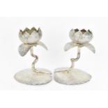 A pair of white metal lotus flower candlesticks, each modelled as an open flower raised on a stemmed