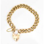 A yellow metal curb link bracelet, the links with engraved detail, with heart shaped padlock and