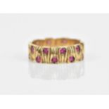 A 9ct yellow gold and ruby Modernist style ring, the band with interlocking textured effect, set
