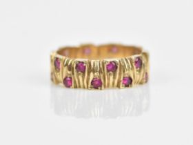 A 9ct yellow gold and ruby Modernist style ring, the band with interlocking textured effect, set